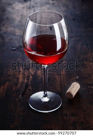 Dark red Merlot or Burgundy Wine with a cork on a wooden background