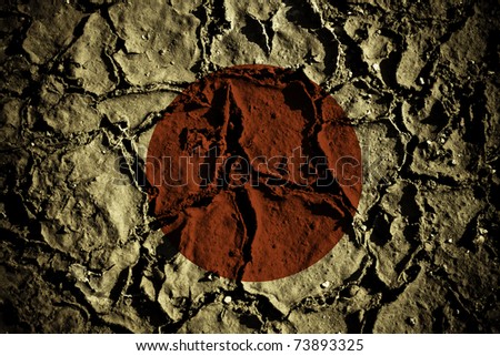 recent earthquakes in japan. stock photo : The flag of japan on cracked soil, symbolizing the recent earthquakes