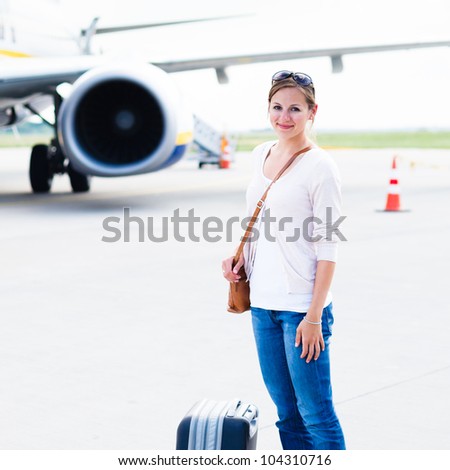 Just arrived: young woman at an airport having just left the aircraft