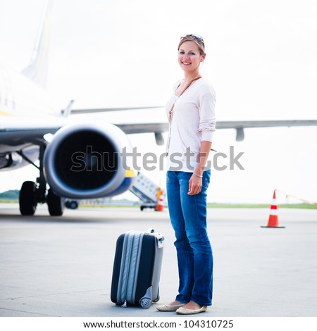 Just arrived: young woman at an airport having just left the aircraft