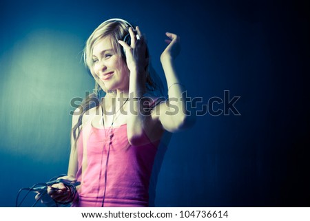 Music please! - Portrait of a pretty young woman/teenager listening to music on her hi-end headphones, enjoying the groove (multiple exposure shot; color toned image)