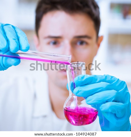 young male researcher carrying out scientific research in a lab  (shallow DOF; color toned image)