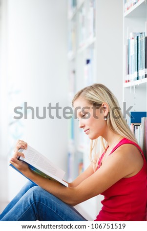 in the library - pretty female student with books working in a high school library (color toned image)