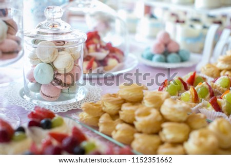 Table setting. Colorful macarons and cakes.