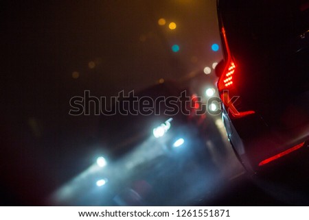 Evening/Night City car traffic - cars on a city road polluting city air with exhaust fumes containing many agents harmful for human health