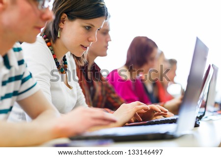 College students sitting in a classroom using laptop computers during class shallow DOF College students sitting in a classroom using laptop computers during class shallow DOF