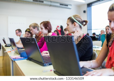 College Students Sitting In A Classroom, Using Laptop Computers During Class (Shallow Dof)