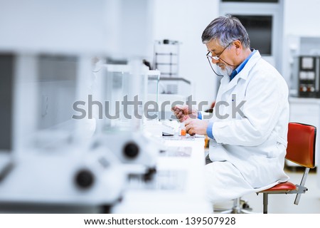 Senior Male Researcher Carrying Out Scientific Research In A Lab (Shallow Dof; Color Toned Image)