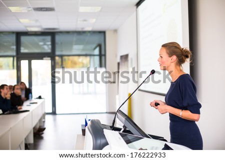 Pretty, Young Business Woman Giving A Presentation In A Conference/Meeting Setting (Shallow Dof; Color Toned Image)