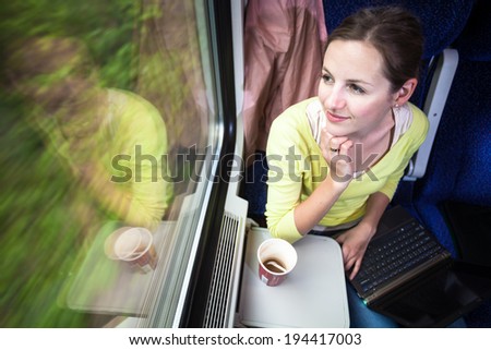 Young woman traveling by train (landscape moving fast behind the window (<--- motin blurred image)