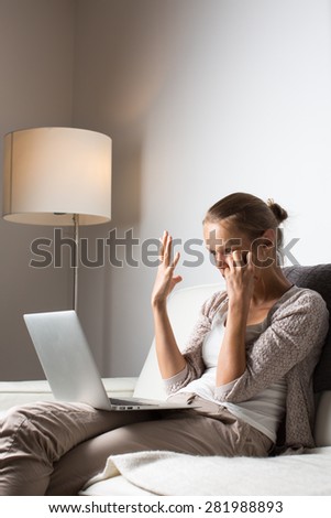 Frustrated young woman, burning the midnigh oil - working late at night on her laptop computer, at home, sitting on sofa, unable to get her numbers right
