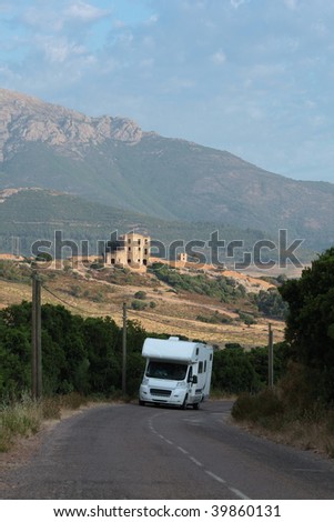 Camper / Trailer / Mobile home / Recreational vehicle / Motor caravan on the move within the beautiful landscape of Corsica, France