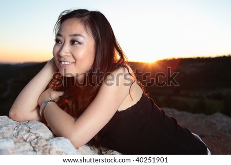 Gorgeous asian/chinese girl enjoying last rays of sun outdoors at the close of the day