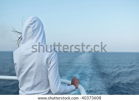 Young woman looking at the ocean from a fast going liner
