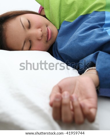 Young woman sleeping peacefully in her bed in her bedroom