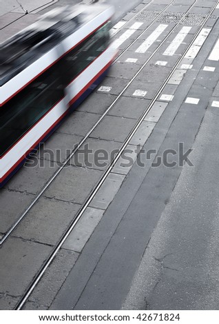 urban traffic concept - city street with a crossing, rail, motion blurred tramway