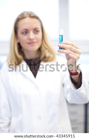 Portrait of a pretty female researcher carrying out experiments in a chemistry/biochemistry research lab