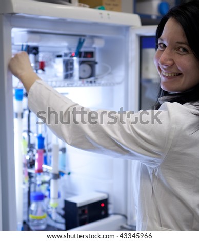 Portrait of a female researcher carrying out research experiments in a lab - researcher taking a substance from a freezer