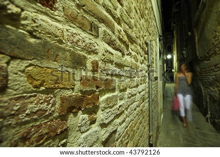 tired young woman coming back alone from a party late at night (motion blur is used to convey movement)