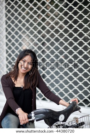 Very pretty young asian woman on bike smiling while commuting/biking to work