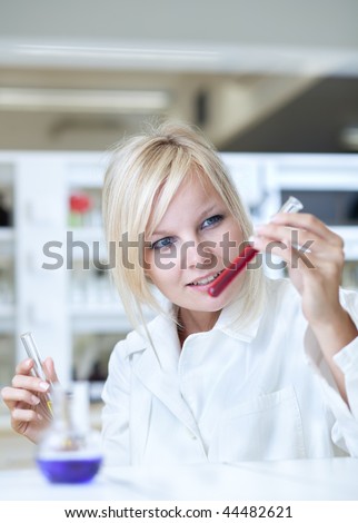 Closeup of a female researcher holding test tubes and carrying out research experiments in a chemistry lab