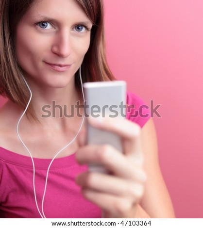 Beautiful young woman listening to music on her portable mp3 player
