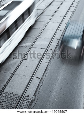 urban traffic concept - city street with a crossing, rail, motion blurred cyclist