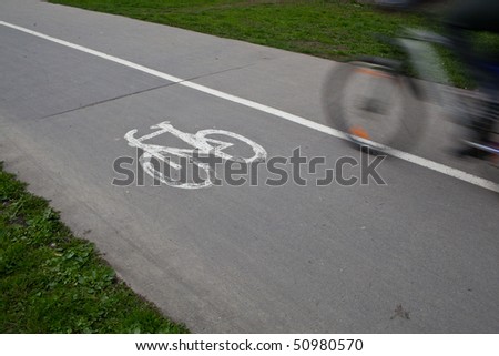 biker on a biking path in a park (motion blur is used to convey movement)