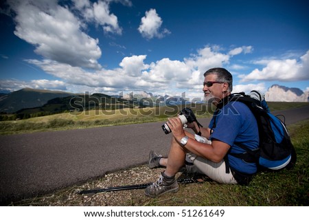 photographer with a camera and a telephoto lens in a lovely summer alpine setting