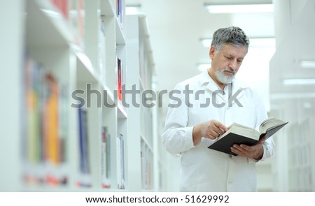 Renowned scientist/doctor/professor in a library of research center/hospital - browsing a book