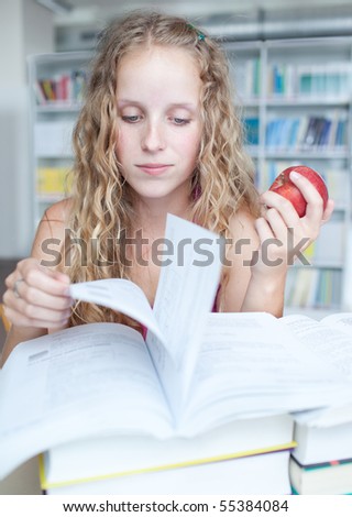 pretty female college student studying in a library/study (color toned image)