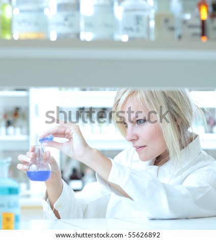 Closeup of a female researcher holding up a test tube and a retort and carrying out some experiments