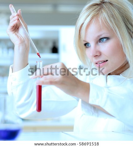 Closeup of a female researcher holding up a test tube and a retort and carrying out experiments