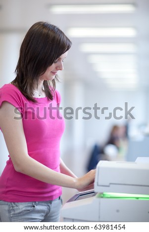 pretty young secretary using a copy machine (shallow DOF; color toned image)
