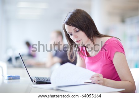 in the library - pretty female student with laptop and books working in a high school library  (color toned image)