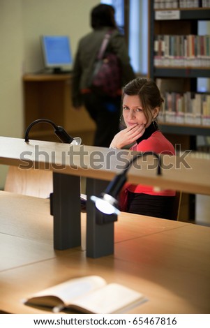 pretty female college student in a college library (shallow DOF; color tuned image)