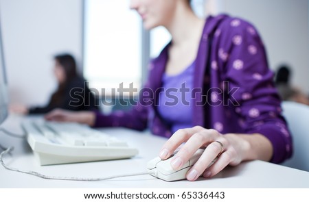 pretty young female college student using a pc in a college library (shallow DOF; color toned image)