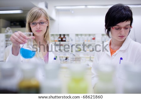two female researchers carrying out research in a chemistry lab (color toned image; shallow DOF)