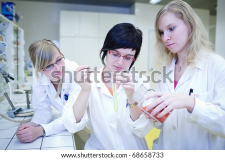 thre female researchers carrying out research in a chemistry lab (color toned image; shallow DOF)