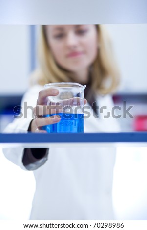 portrait of a female researcher carrying out research in a chemistry/biochemistry lab (color toned image; shallow DOF)