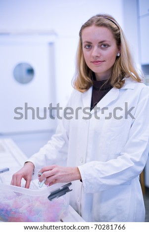 Closeup portrait of a female researcher carrying out experiments in a laboratory  (color toned image)