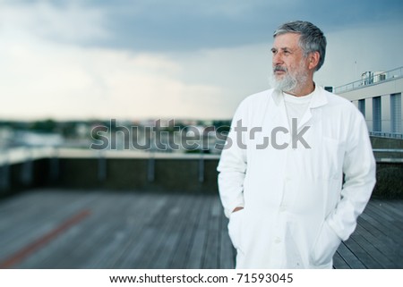 renowned scientist/doctor standing on the roof of the research center/hospital looking confident (color toned image)