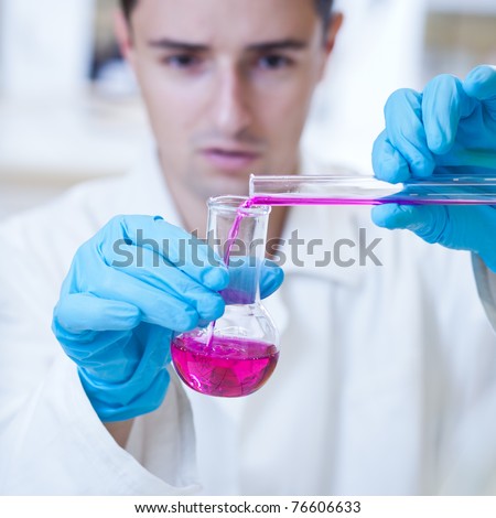 young, male researcher carrying out scientific research in a lab (color toned image; shallow DOF)