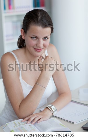 close-up portrait of a pretty female college student studying in the university library/study room (color toned image)