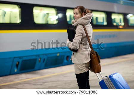 Train is coming - young woman waiting for her connection in a modern train station (shallow DOF)