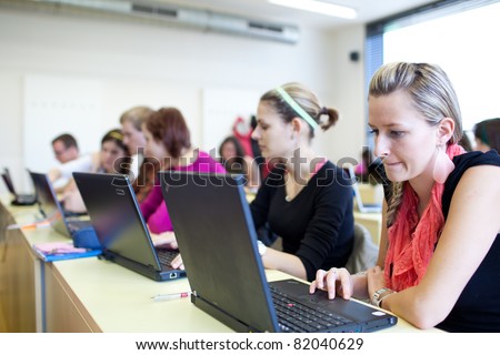 college students sitting in a classroom, using laptop computers during class (shallow DOF)