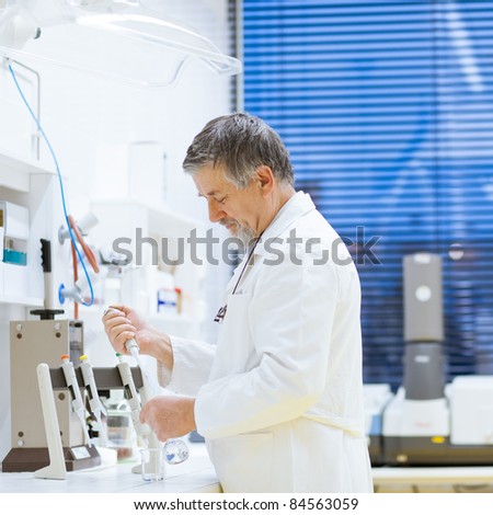 senior male researcher carrying out scientific research in a lab using a gas chromatograph (shallow DOF; color toned image)