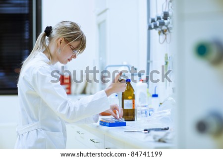 female researcher carrying out research experiments in a chemistry lab (color toned image; selective focus - shallow DOF)
