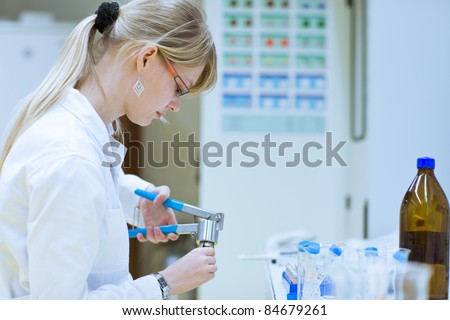 Closeup of a female researcher/chemistry student carrying out research experiments in a chemistry lab (color toned image)