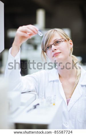 portrait of a female researcher/chemistry student carrying out research in a chemistry lab (color toned image; shallow DOF)
